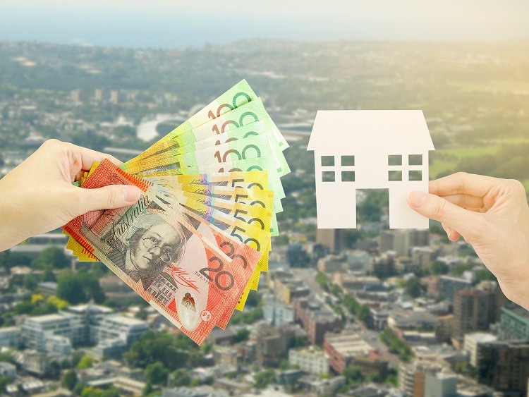 Australian money and a cut out of a house over an Australian suburb