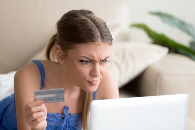 A confused woman is confronted with mortgage fees at her laptop