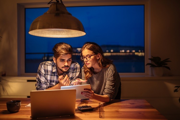 A couple examine a mortgage pre-approval application at home on their computer