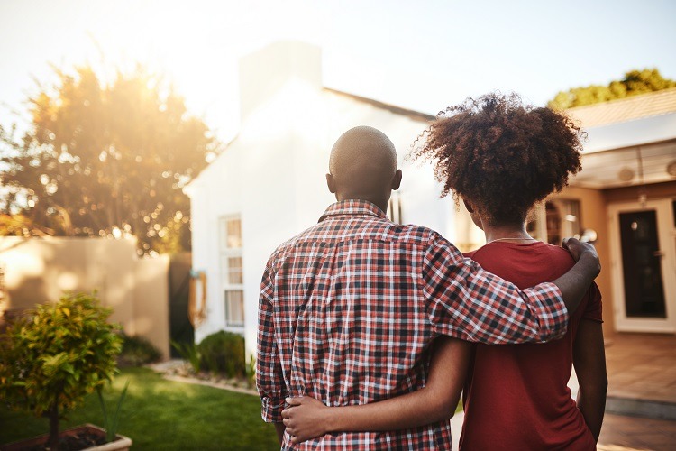 A couple looking at a house before purchasing