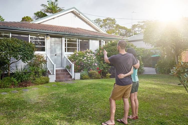 A couple stand outside a prospective new property in Australia