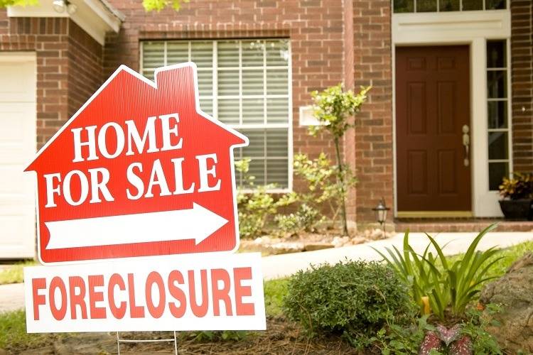 A foreclosure For Sale sign in front of a home